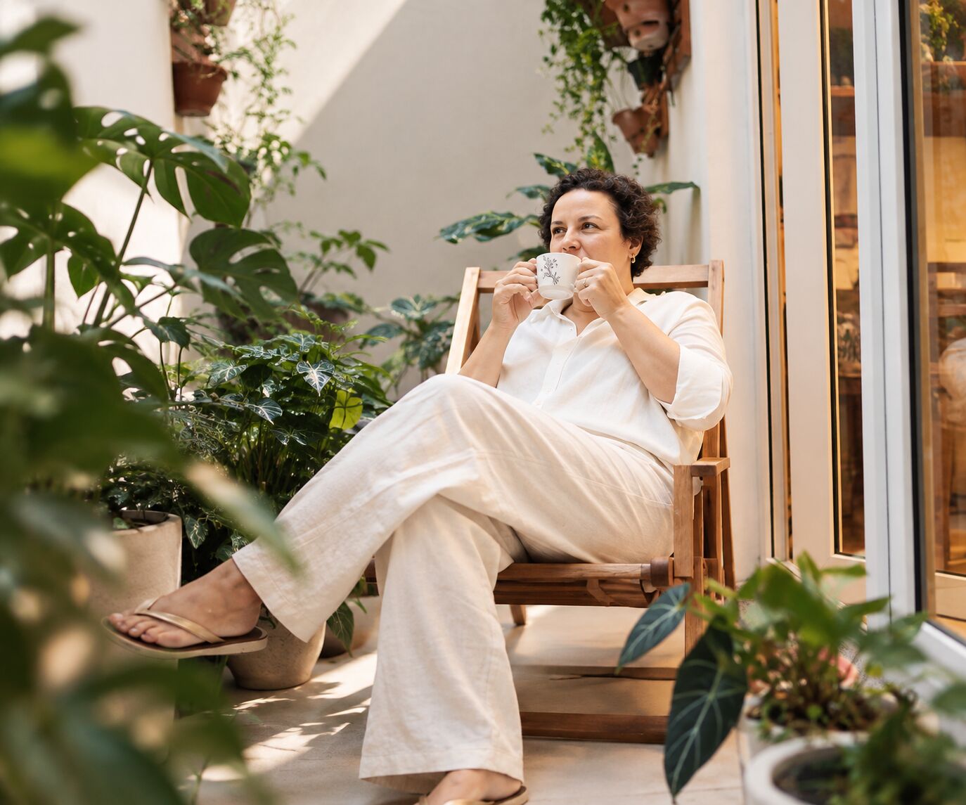 Mulher tomando café em momento de pausa, refletindo sobre o que realmente importa na sua rotina